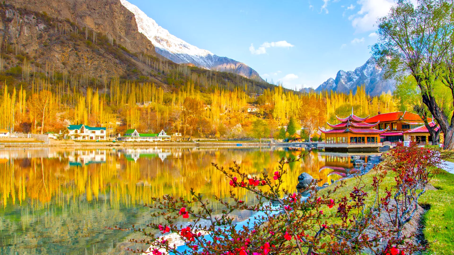 Vibrant autumn view of Shangrila Resort in Skardu, Pakistan, with colorful trees and clear blue skies.