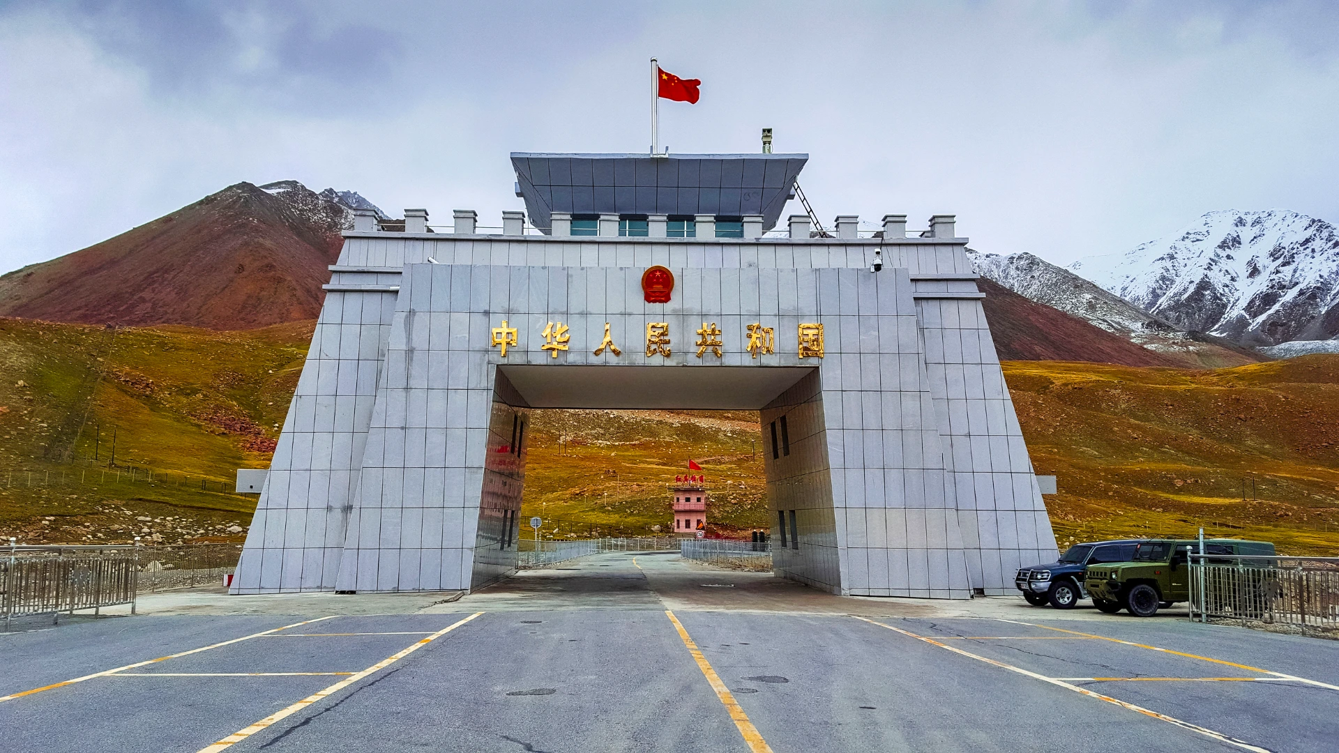 A close-up view of the gate at Khunjerab Pass, adorned with intricate designs against a backdrop of snowy mountains.