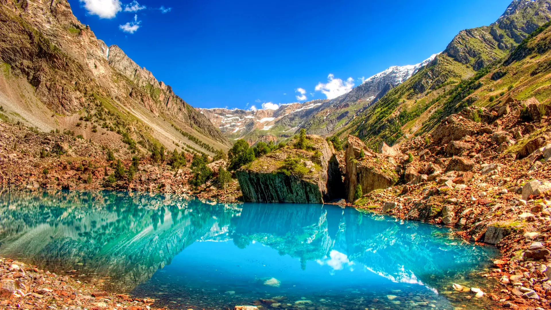 A stunning view of the Blue Lake in Naltar Valley, with its crystal-clear turquoise waters reflecting the surrounding mountains.