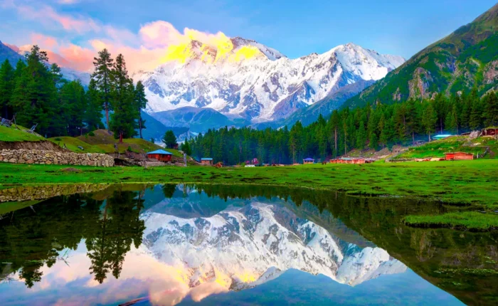 Reflection Pond at Fairy Meadows with Nanga Parbat in the background, Pakistan, showcasing clear water reflecting the towering snow-capped mountain and lush greenery.