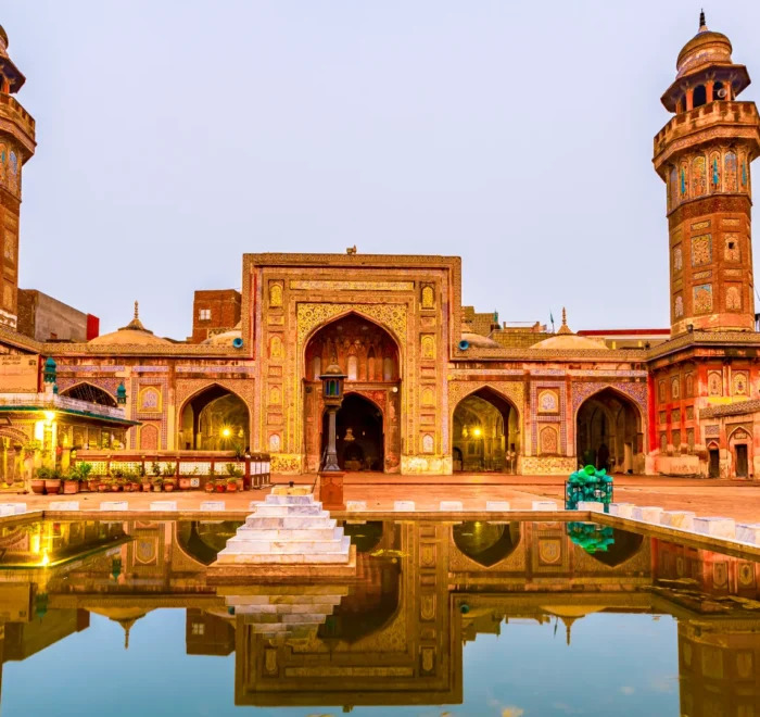 Front view of the Wazir Khan Mosque in Lahore, Pakistan, showcasing its intricate architecture and vibrant colors.